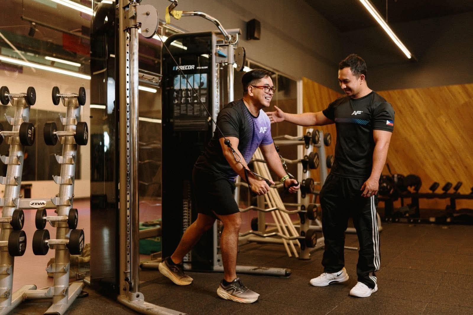 Coach Richard guiding a client on the cable machine