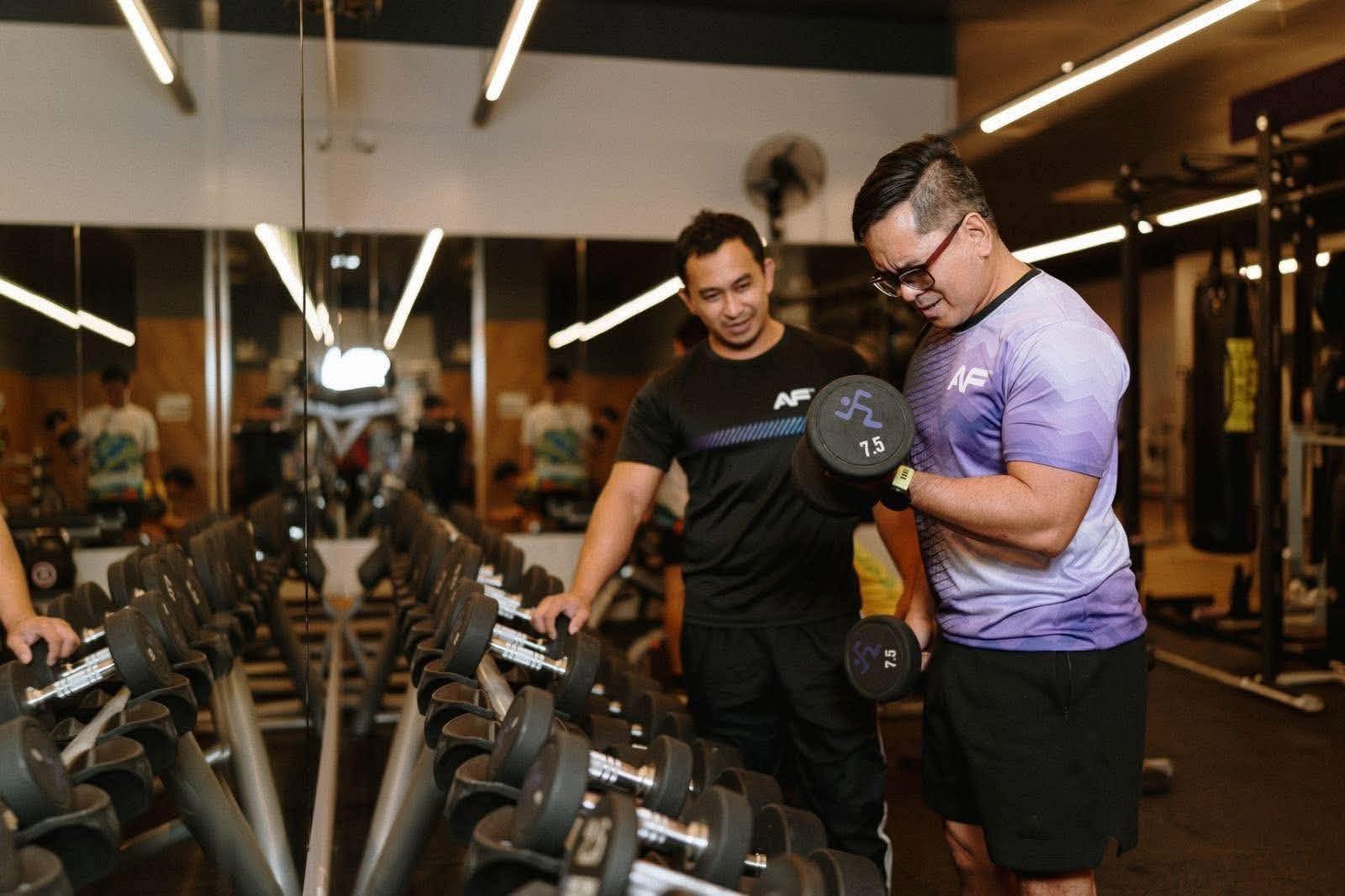 Coach Richard spotting a client during dumbbell work